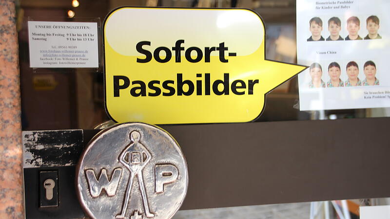 &Uuml;ber der T&uuml;rklinke klebt der Hinweis: Im Laden Willemer und Prause gibt es die Option, Passfotos anfertigen zu lassen.