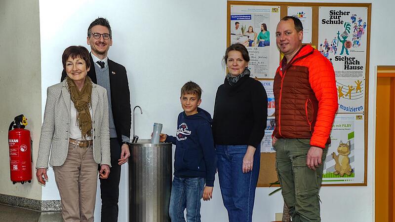Rektorin Barbara Buz, Bürgermeister Jan Marberg (SPD), Stadträtin Heike Greenberg-Kremser (CSU) und Roland Sauer aus dem städtischen Baubüro weihten gemeinsam mit dem Drittklässler Elias (Bildmitte) am Montag symbolisch die neue Trinkwasserstation...