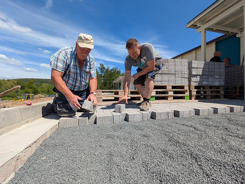 Horst Hartmann (links) zeigt Andreas May wie es geht: Der Mann mit 50 Jahren Bau-Erfahrung duldet auf seiner Baustelle keine Schlamperei.
