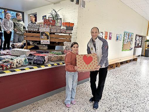 Eine Schülerin übergibt ihr liebevoll verziertes Päckchen an Herrn Handel von „Das kunterbunte Kinderzelt“. Eine Schülerin übergibt ihr liebevoll verziertes Päckchen an Herrn Handel von „Das kunterbunte Kinderzelt“.