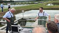 Bundeslandwirtschaftsminister Alois Rainer (l.) und Landrat Christian von Dobsch&uuml;tz (Neustadt/Aisch-Bad Windsheim) ziehen die ersten Karpfen der Saison aus dem Hallweiher bei Oberlindach.
