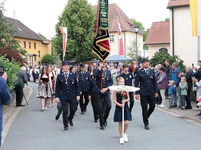 Die Jubil&auml;umsfeuerwehr f&uuml;hrt den Festzug durch Weigelshofen an.