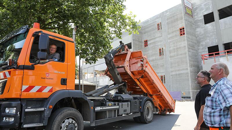 Bauhof-Mitarbeiter Winfried Schüpferling (von links) lädt im Schatten des Healthineers-Megabaus sein tonnenschweres Fahrzeug ab. Beim Umzug des Lagerplatzes schwingt für ihn und seine Kollegen Gerhard Honeck und Walter Neubauer etwas Wehmut, aber auch Vorfreude mit.Forchheim & Fränkische Schweiz