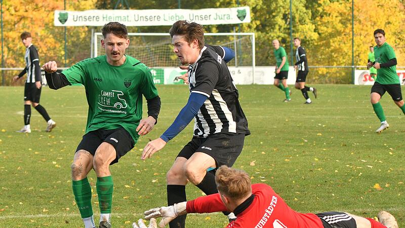 Der Burgkunstadter Schlussmann Leon Thum schnappt sich den Ball bevor der Arnsteiner Julian Betz (l.), der sich im Laufduell mit Nils Straten befindet, an den Ball kommt.