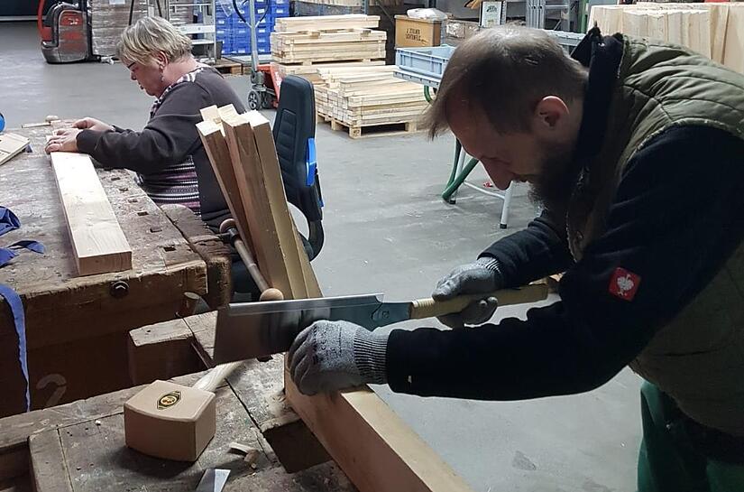 Die Werkst&auml;tten-Mitarbeiter Iris Topeters und Sascha Joyce beim Zurichten der Holzkomposter.
