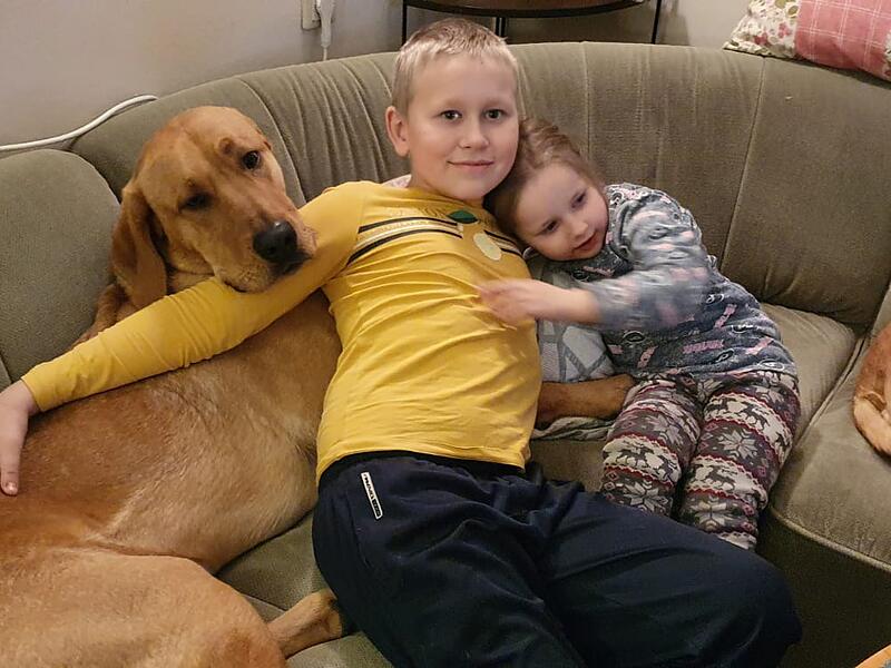 Zwei Kinder, bewacht und geliebt von den riesigen Hunden der Gastfamilie.