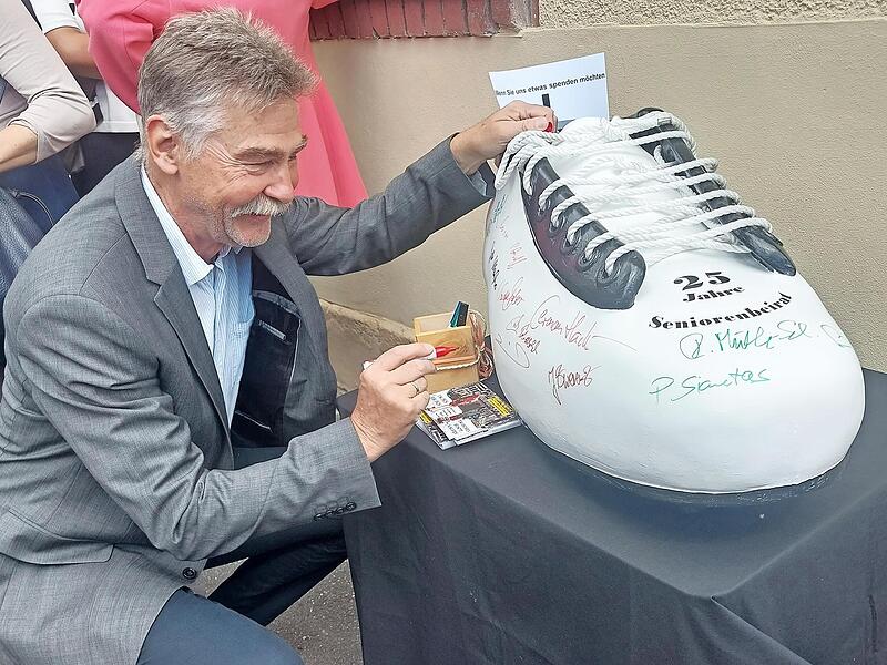 Hans-J&uuml;rgen Heinzel sowie viele G&auml;ste signierten den Herzo-Schuh, den die Mitglieder des Seniorenbeirats der VHS abgeluchst hatten.