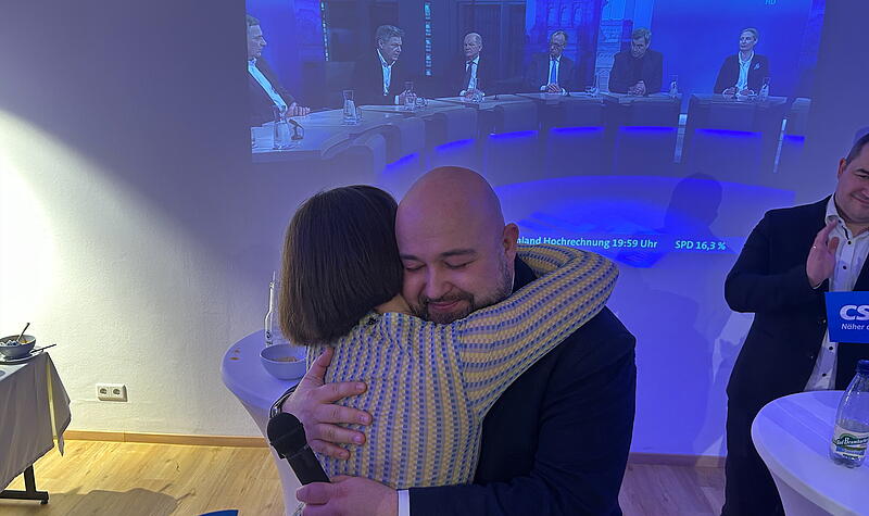 Jonas Geissler umarmt nach seinem erneuten Mandatsgewinn für den Bundestag bei der Wahlparty in Coburg Ehefrau Anne-Sophie Göbel.