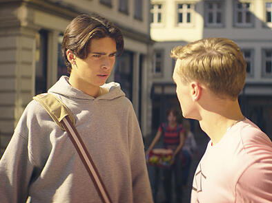 Ernstes Gespräch im Film "Die Schule der magischen Tiere 3": Loris Sichrovsky (Jo) konfrontiert Luis Vorbach (Silas) vor einem Modeladen an der Oberen Brücke in Bamberg. Im Hintergrund kommt Emilia Maier (Ida) angeradelt.