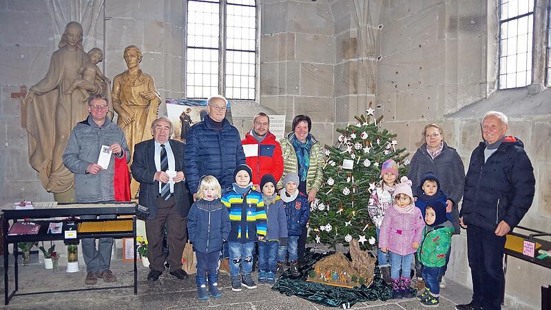 Auch heuer schmückten Kinder der Rosenberg-Kita den Christbaum in der St.-Anna-Kapelle. Gemeinsam mit den Hauptorganisatoren Werner Müller (Dritter von links), Lukas Löffler (Vierter von links), Siegfried Schneider (rechts) sowie (von links) KEB-Geschäftsführer Stephan Renczes und KEB-Vorsitzender Heinz Hausmann laden sie zum Krippen-Spaziergang ein.