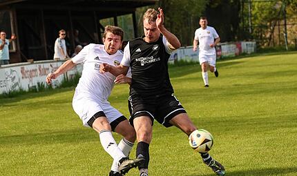 Neufangs Jonas M&uuml;nzel (schw.) kommt einen Hauch zu sp&auml;t, um den Flankenball des Steinbacher Kapit&auml;ns Lukas Fischer zu verhindern.