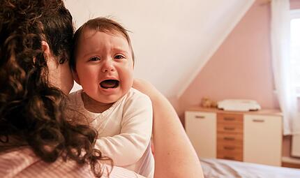 Eine junge Frau tr&ouml;stet  in einer Wohnung ihr weinendes Baby. In vielen Bereichen soll  der Reformstau behoben werden, aber die Familien scheinen dabei zu kurz zu kommen.