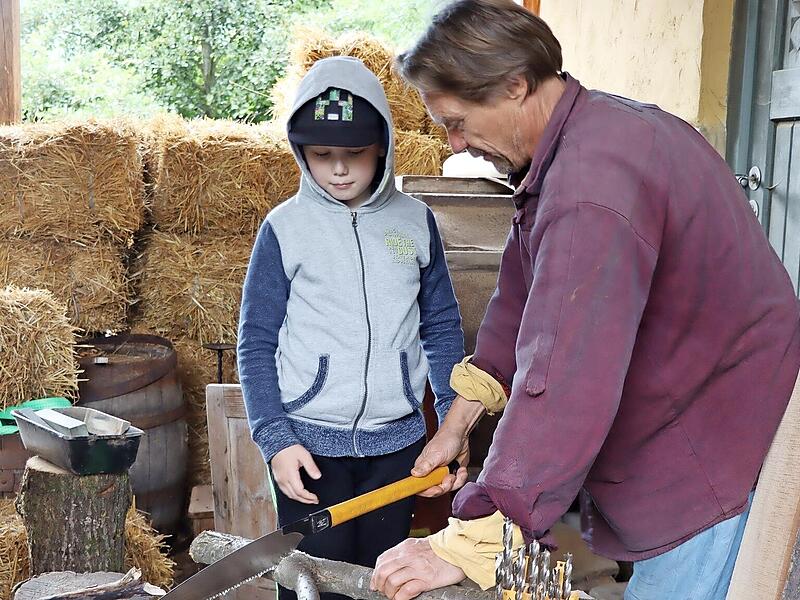 Gerne hilft Holzexperte Eckart Henzler den Kindern beim Sägen.