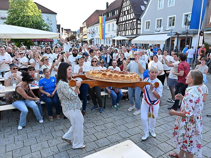Die beiden B&uuml;rgermeisterinnen Christiane Meyer (links) und Isabelle Moinet stemmen den Brioche in Ebermannstadt..
