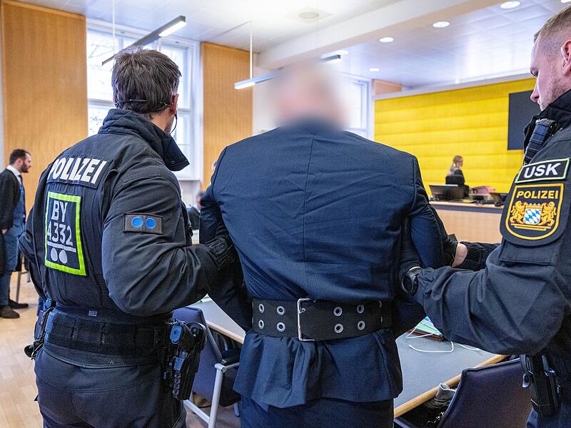 Polizisten bringen Angeklagten ins Gericht Polizisten bringen Angeklagten ins Gericht