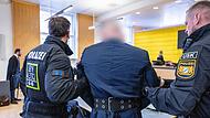 Polizisten bringen Angeklagten ins Gericht Polizisten bringen Angeklagten ins Gericht