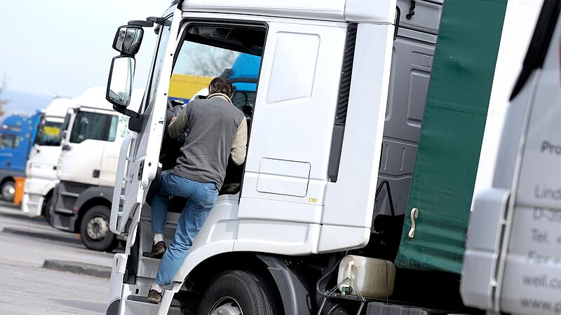 Ein Fernfahrer steigt in seinen LKW