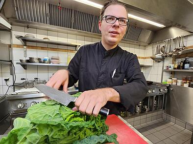 Marco Schneider mit Bamberger Wirsing, der mit japanischen Aromen zu ungewöhnlichen Gerichten verarbeitet wird. Das  „Kuro Neko“, benannt nach der schwarzen Glücksbringer-Katze  der Japaner, hat ab sofort geöffnet.
