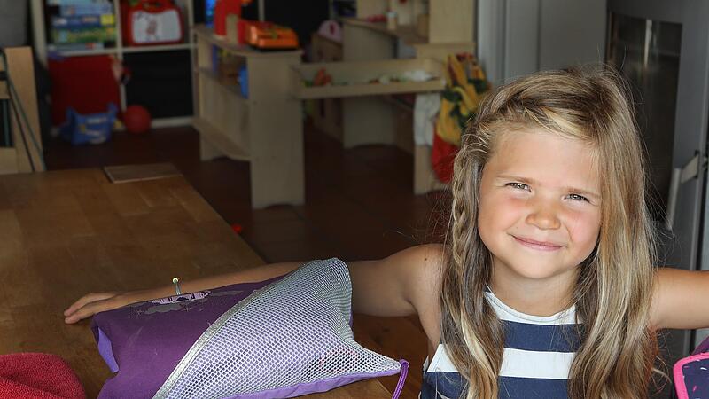 Momo Niebler packt ihren Rucksack und ist bereit für die Grundschule. Neben Federmäppchen, Sportbeutel und Malsachen kommt auch eine Schutzmaske ins Gepäck.