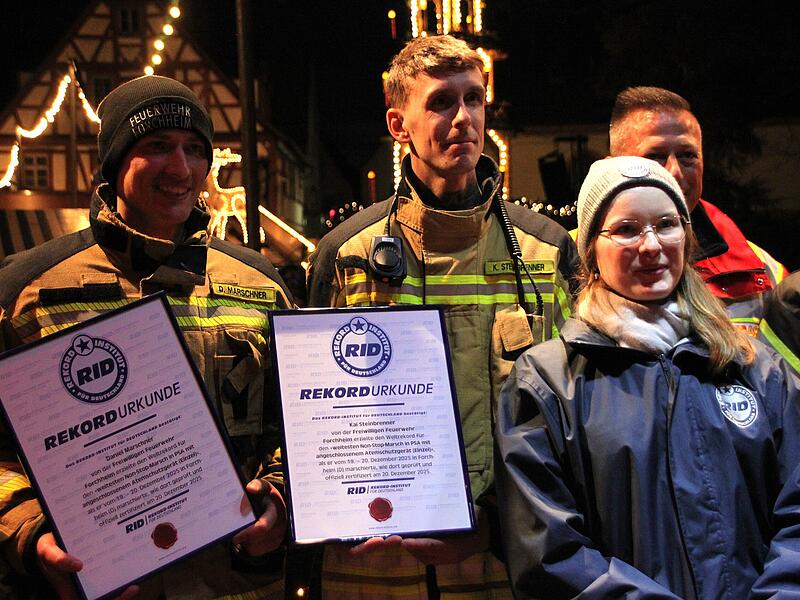 (Von links) Daniel Marschner und Kai Steinbrenner mit ihren Weltrekord-Urkunden. Rekordrichterin Laura Kuchenbecker vom Rekord-Institut f&uuml;r Deutschland attestierte den Weltrekord im Non-Stop-Marsch mit Atemschutzger&auml;t.