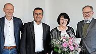 Jürgen Schäfer (Leitung Finanzen, Administration & Personal), Geschäftsführer Dr. Abassin Aryobsei (CEO), Petra Heim und Geschäftsführer Peter Mayr bei der Gratulation zum Betriebsjubiläum und der Übergabe der IHK-Ehrenurkunde.