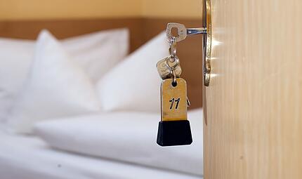 Ein Zimmerschl&uuml;ssel h&auml;ngt in einem G&auml;stehaus