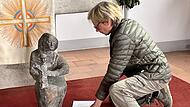 Maria Rucker hilft bei der Suche nach dem idealen Platz für die Figur in der Kirche.
