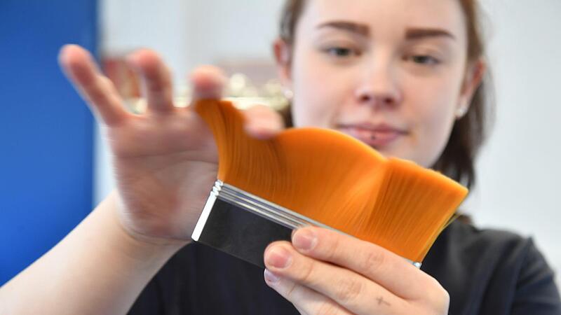 Michelle M&uuml;ller streicht &uuml;ber einen Pinselkopf. Soeben hat sie die Pinselhaare in der Metallzwinge befestigt.