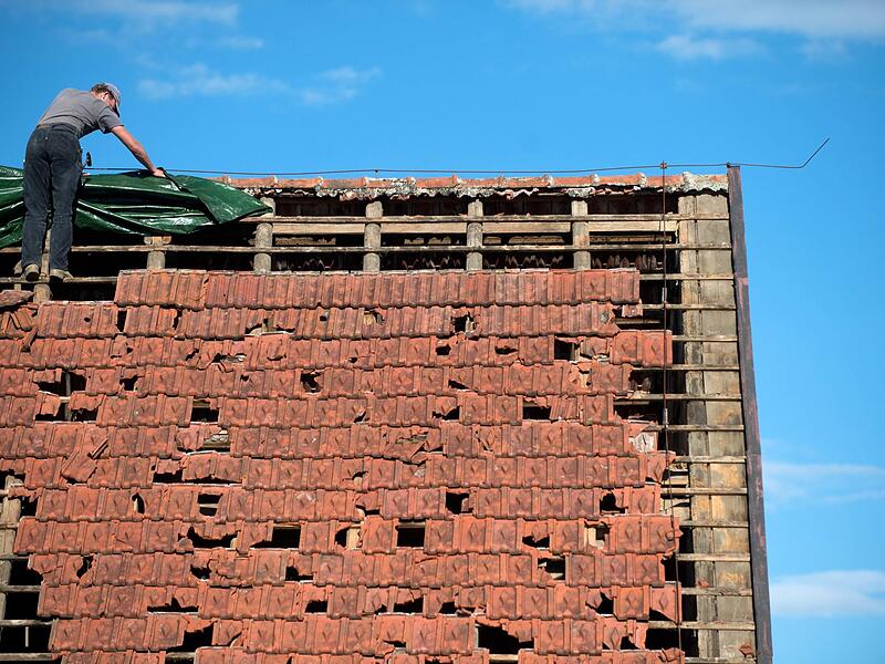 Unwetter können an Dächern  schwere Schäden anrichten. Eine Wohngebäudeversicherung kommt in der Regel für die Kosten auf.