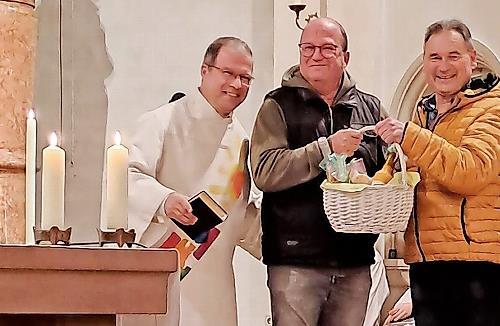 Unser Bild zeigt Diakon Manfred M&uuml;ller, Organist Harald Drescher und Kirchenpfleger Bernd H&uuml;fner bei der &Uuml;bergabe des Geschenkkorbs.