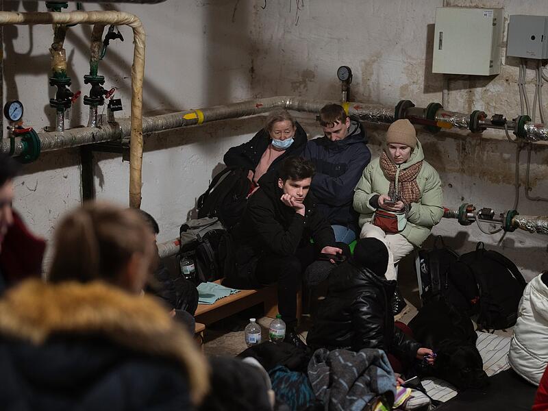 Menschen suchen Schutz in einem Keller eines Gebäudes, während die Sirenen neue Angriffe ankündigen. Russland hat am Donnerstag einen umfassenden Angriff auf die Ukraine gestartet und Städte und Stützpunkte mit Luftangriffen oder Granaten beschossen.