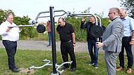 Walter Nussel, CSU-Landtagsabegeordneter, Pfarrer Jens Arnold, Bürgermeister Karsten Fischkal, Pfarrer Thomas Ringer und stellvertretender Landrat Martin Oberle (von links) nehmen eines der Übungsgeräte für Rolli-Fahrer in Adelsdorf in Augenschein.