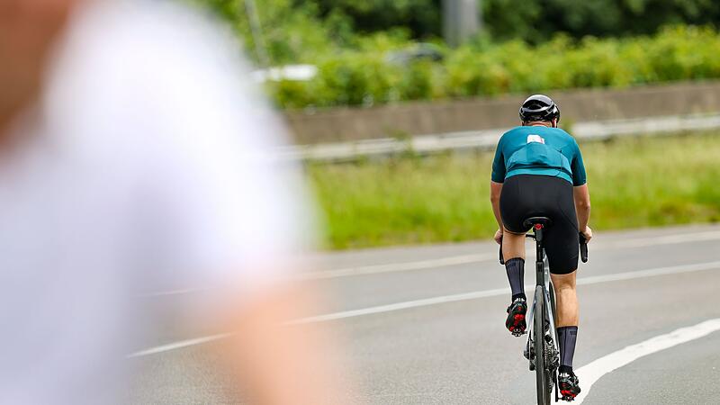 Ein Radfahrer f&auml;hrt in der Sonne auf seinem Rennrad