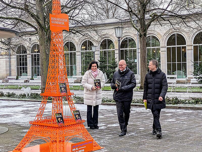 39. Kissinger Sommer 2025 Kuratoriumsvorsitzende Dorothee Bär und Oberbürgermeister Dirk Vogel bestaunen mit Festival-Intendant Alexander Steinbeis (rechts) den Pariser Eiffelturm im Kurgarten, das Symbol für den Kissinger Sommer 2025.
