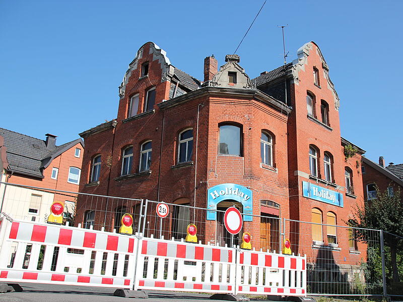 Neustadt bei Coburg: Gebäude einsturzgefärdetGebäude in Neustadt bei Coburg einsturzgefährdet Blick auf das einsturzgefährdete Gebäude aus Richtung Marienstraße. Hier ist nur der Gehweg auf der Gebäude-Seite gesperrt. Die Holiday-Schilder erinnern an die Vergangenheit als Kneipe.