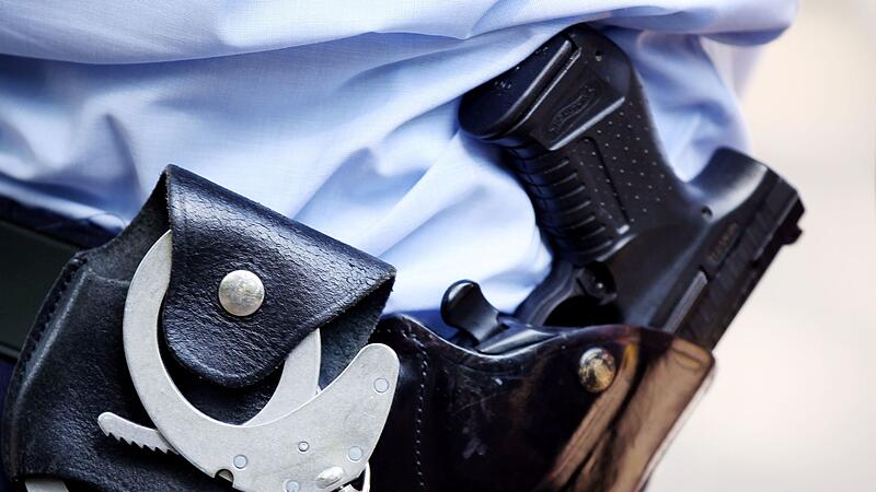 Ein Polizist mit Handschellen und Pistole am G&uuml;rtel